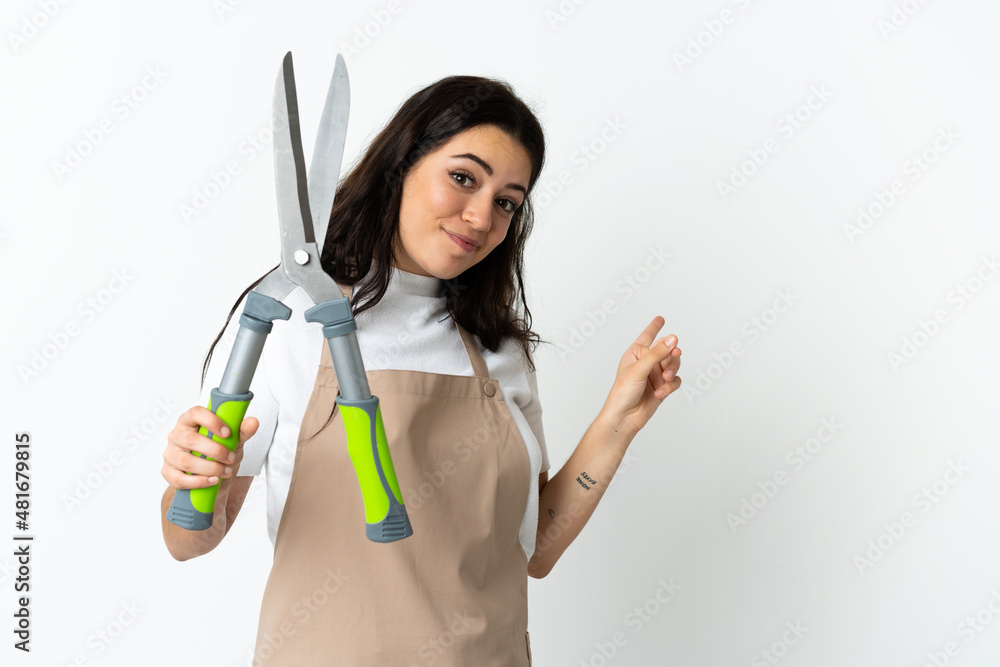 Young caucasian woman holding a plant isolated on white background pointing back Young caucasian woman holding a plant isolated on white background pointing back