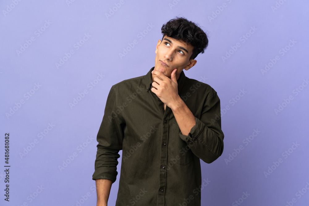 Young Argentinian man isolated on background having doubts Young Argentinian man isolated on background having doubts