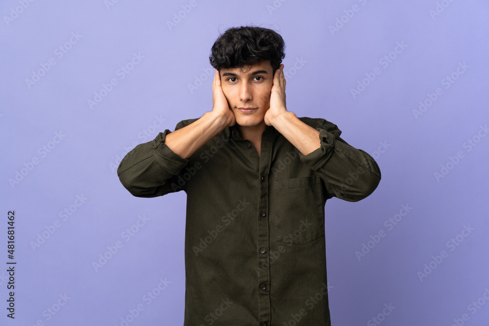 Young Argentinian man isolated on background frustrated and covering ears Young Argentinian man isolated on background frustrated and covering ears