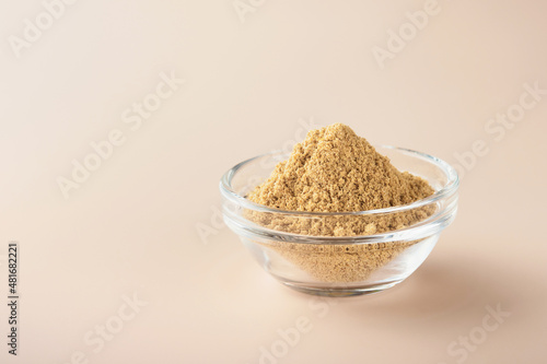 Flax fiber. Ground flaxseeds in glass bowl soluble fiber supplement for intestinal on a beige background. Superfood for healthy. Copy space, free space, space for text.