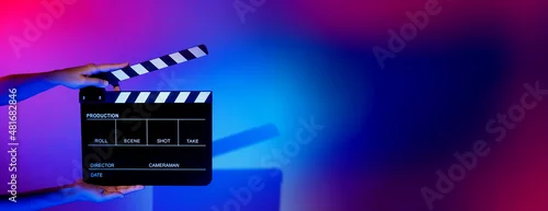 Panel kuchenny z motywem Blurry images of movie slate or clapper board. Hand holds empty film making clapperboard on color background in studio for film movie shooting or recording. Film slate for Youtuber video production.