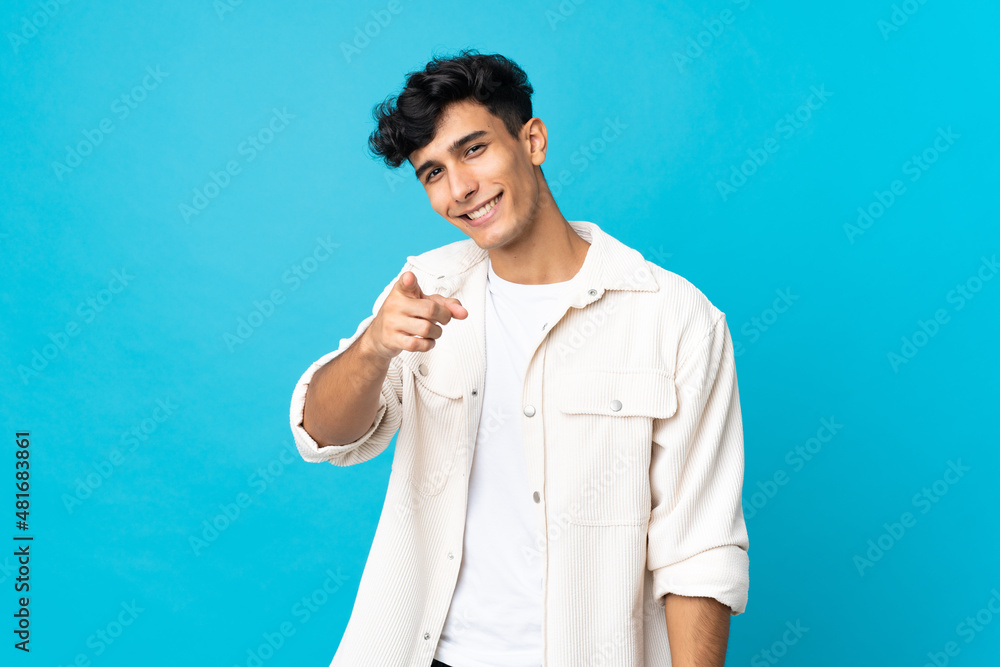 Young Argentinian man isolated on background pointing front with happy expression Young Argentinian man isolated on background pointing front with happy expression