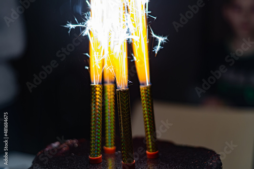 Burning candles-fireworks stand with a blazing fire in a festive cake.