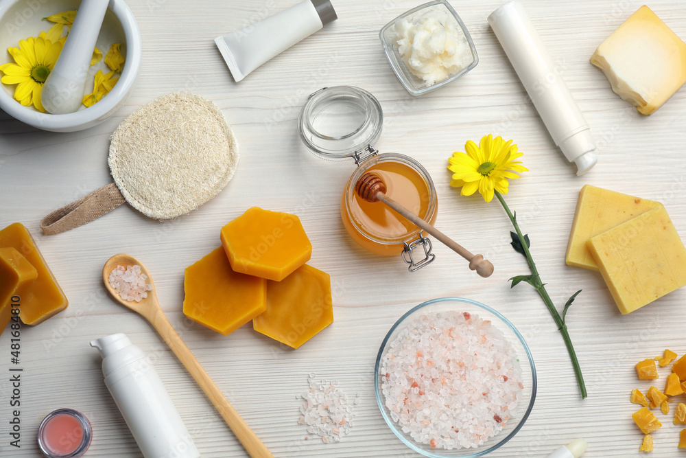 Flat lay composition with beeswax and cosmetic products on white wooden table Flat lay composition with beeswax and cosmetic products on white wooden table