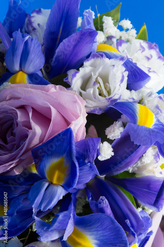 Fototapeta Naklejka Na Ścianę i Meble -  Fresh flower bouquet with blue irises, white and pink roses and lily, floral background