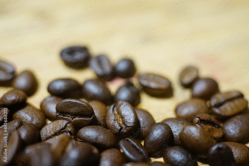 Kaffee Bohnen im Detail auf einem hölzernen Untergrund mit schönem Verlauf der Unschärfe und klassischem Bildlook Kaffee Bohnen im Detail auf einem hölzernen Untergrund mit schönem Verlauf der Unschärfe und klassischem Bildlook