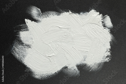 Tableau sur toile Strokes of white oil paint on black canvas, top view