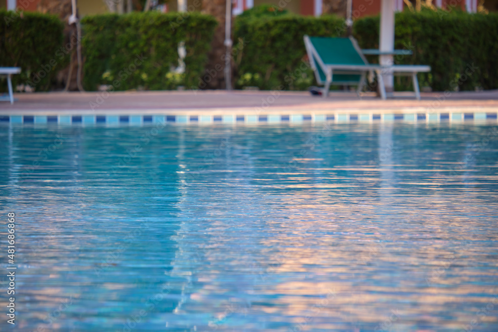Obraz premium Blue clear water with small ripple waves in swimming pool at tropical resort. Summer vacations concept
