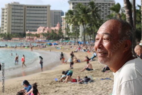Senior man staring at the ocean at Waikiki Beach in Hawaii 