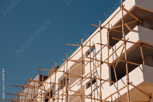 Construction building houses made of stone and sandstone using scaffolding in Egypt  blue sky