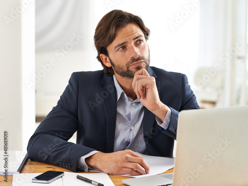Contemplating his next business proposal. A handsome businessman reflecting over his thoughts while at his desk.