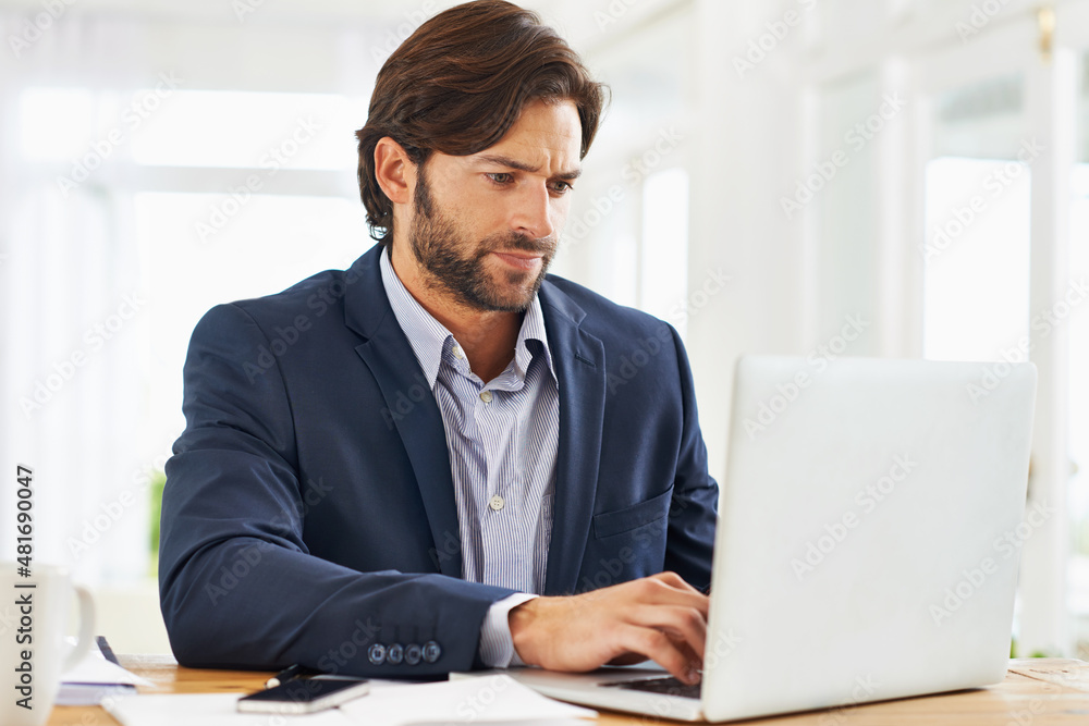 Work is a breeze today. A handsome businessman working on his laptop. Work is a breeze today. A handsome businessman working on his laptop.