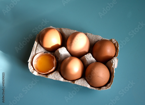 Cardboard box for fresh organic eggs x6 egg food with yolk, shell and open back from the market. Top view zoom close up. Ingredient for cooking omelet, boiled egg, fried egg, cake. photo