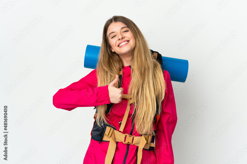 Young mountaineer woman with a big backpack over isolated background giving a thumbs up gesture Young mountaineer woman with a big backpack over isolated background giving a thumbs up gesture
