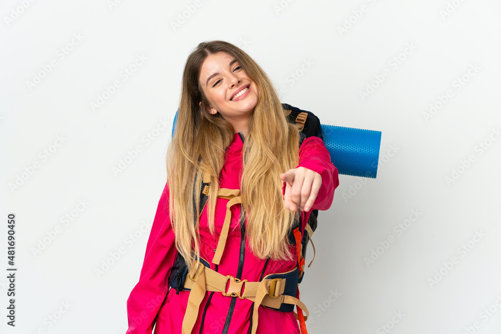 Young mountaineer woman with a big backpack over isolated background pointing front with happy expression Young mountaineer woman with a big backpack over isolated background pointing front with happy expression