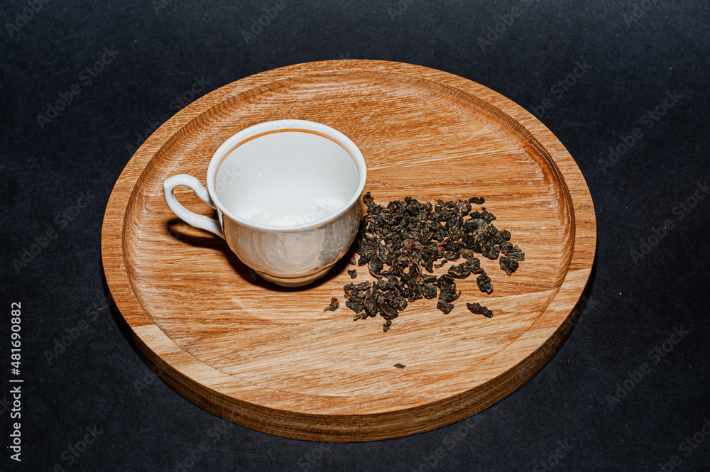 Dry tea with green leaves in wooden spoons, on black background. Dry tea with green leaves in wooden spoons, on black background.