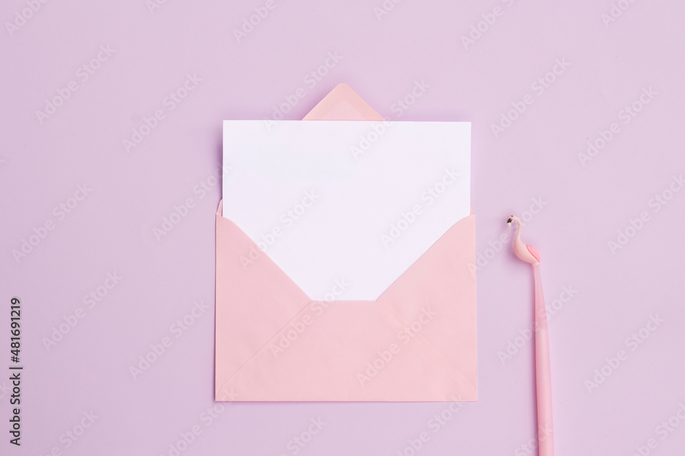 Blank white paper in pink envelope with pink flamingo shaped pen on lilac - pink background. Blank white paper in pink envelope with pink flamingo shaped pen on lilac - pink background.
