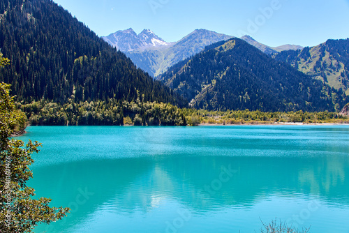 panoramic scenic view of the mountain lake and the slopes of the mountains covered with fir trees