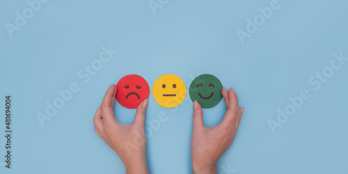 Mental health concept. Hand choosing happy smile face paper cut, good feedback rating and positive customer review, satisfaction survey , mental health assessment, child wellness, world mental health 