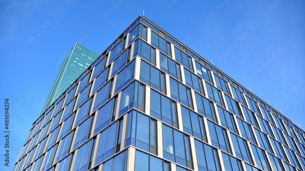 Modern glass corporate architecture with reflection of sky on the facade a sunny day - obrazy, fototapety, plakaty 