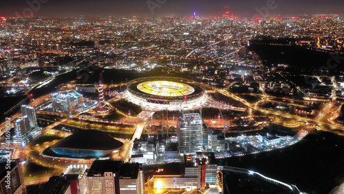 Aerial drone night shot of iconic illuminated London Stadium facilities in Queen Elizabeth Park, London, United Kingdom photo