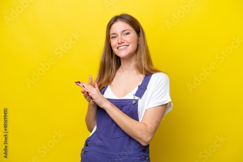 Young caucasian woman isolated on yellow background applauding