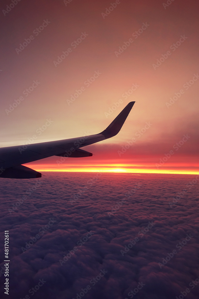 Sunset on cloudy sky as seen from a window plane above fluffy clouds Sunset on cloudy sky as seen from a window plane above fluffy clouds