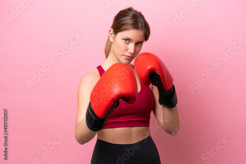 Young caucasian woman isolated on pink background with boxing gloves © luismolinero