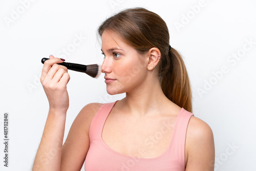 Young caucasian woman isolated on white background holding makeup brush