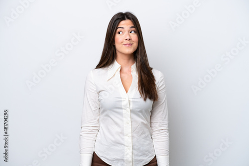 Young Brazilian woman isolated on white background making doubts gesture looking side © luismolinero