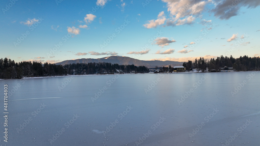 Wunderschöne Aufnahmen des zugefrorenen Faaker Sees + Insel in Österreich / Kärnten bei Sonnenuntergang - beautiful photograph of a frozen lake in Carinthia - Austria at sunset  -dji mavic 3 cine  4k 