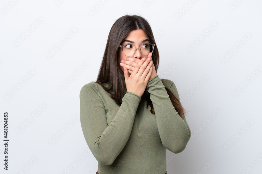 Young Brazilian woman isolated on white background covering mouth and looking to the side Young Brazilian woman isolated on white background covering mouth and looking to the side