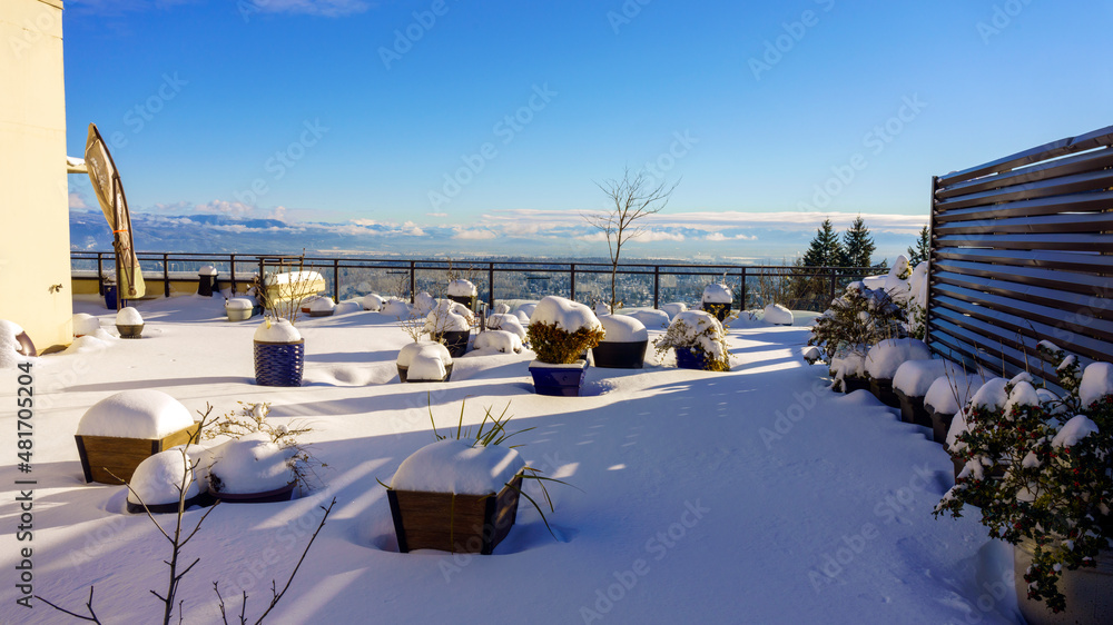 Snowed-in patio garden overlooking valley in winter.