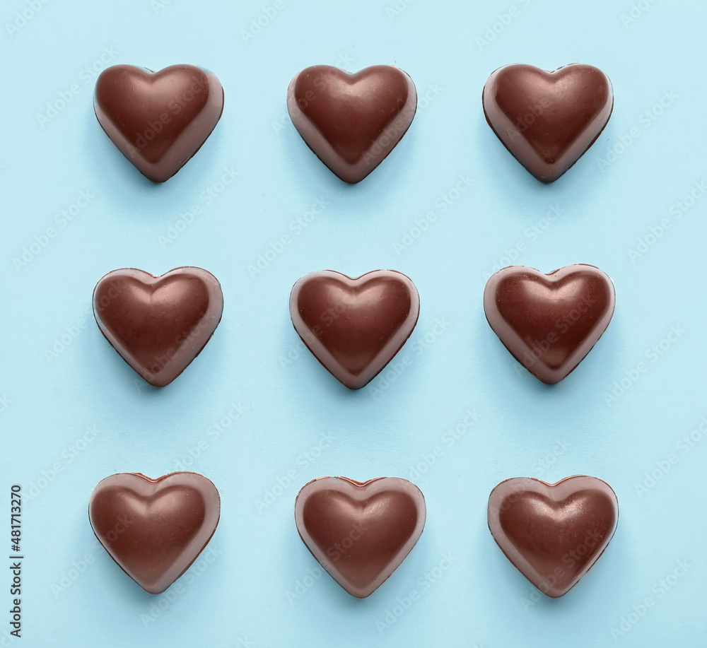 Tasty heart-shaped candies on blue background