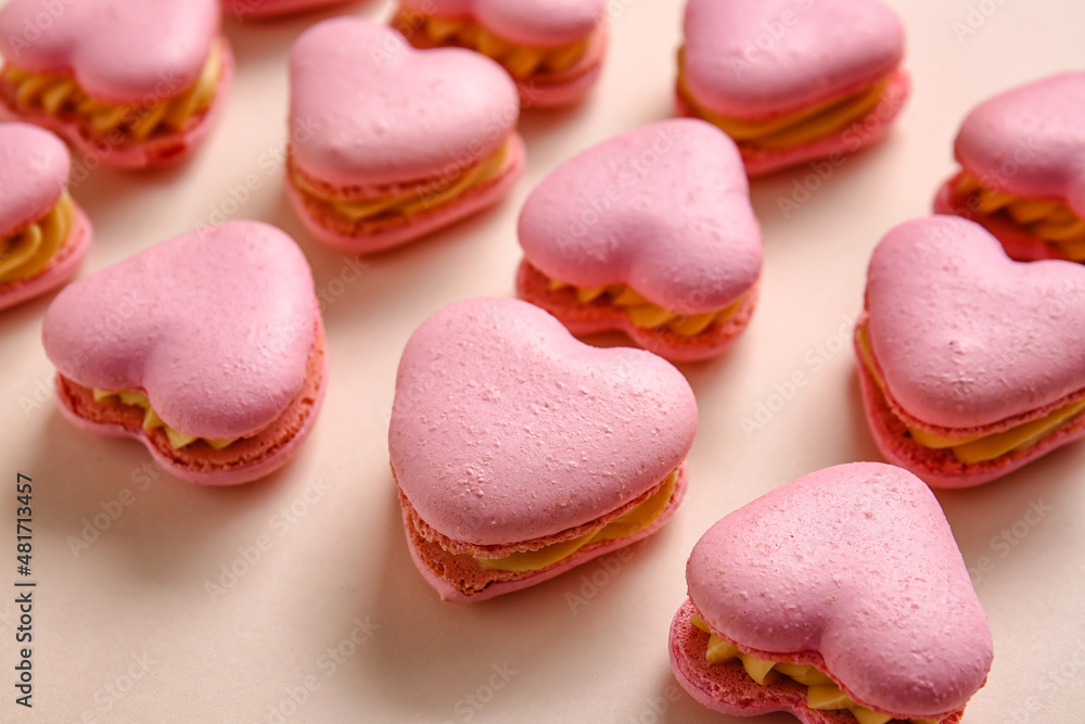 Tasty heart-shaped macaroons on beige background, closeup Tasty heart-shaped macaroons on beige background, closeup