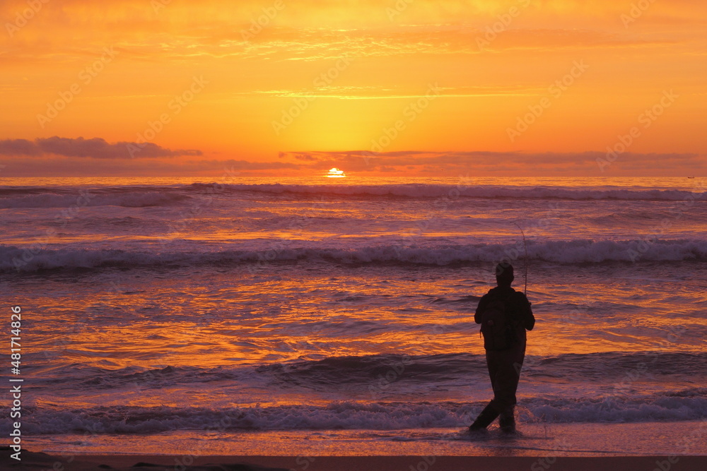 silueta de pescador amateur en la puesta de sol, pesca deportiva, pesca recreativa en la playa