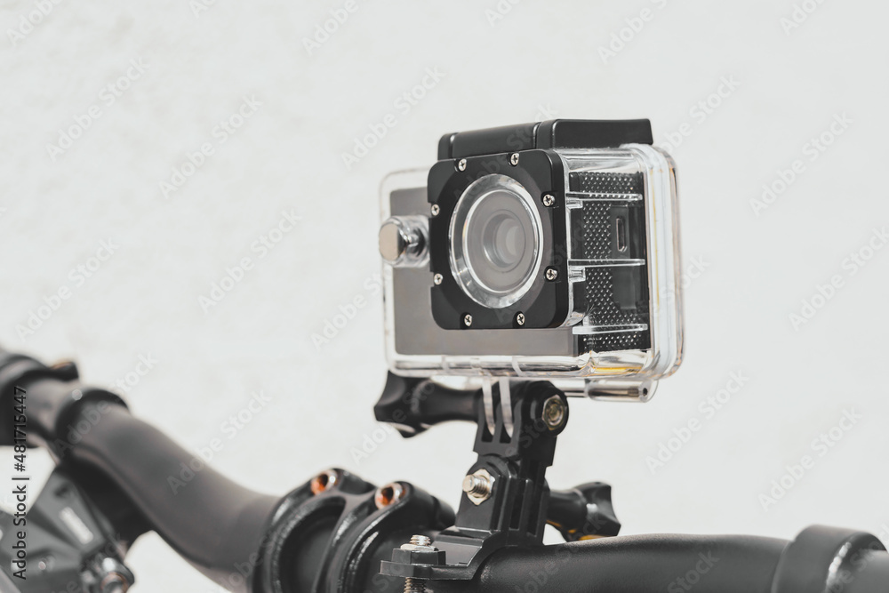 Close-up, waterproof, action camera on the handlebars of a bicycle. light wall background.