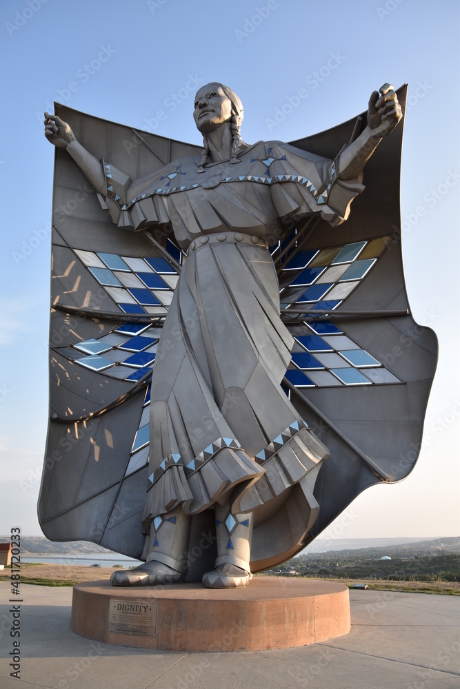 Dignity" statue depicting a Native American woman holding a star quilt