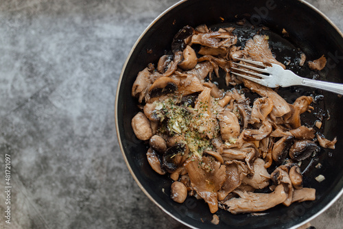 Plate of cooked forest mushrooms garlic and parsley. Autumn and healthy food recipe.