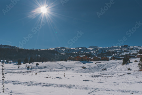 A picturesque landscape view of the snowcapped French Alps mountains and the ski resort buildings on a cold winter day (La Joue du Loup, Devoluy) photo