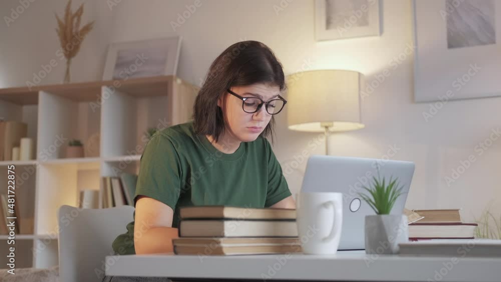 Work fatigue. Exhausted student. Job burnout. Tired sleepy overworked woman workaholic typing at laptop desk home workplace at evening.