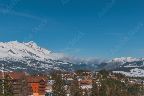 A picturesque landscape view of the snowcapped French Alps mountains and the ski resort buildings on a cold winter day (La Joue du Loup, Devoluy)