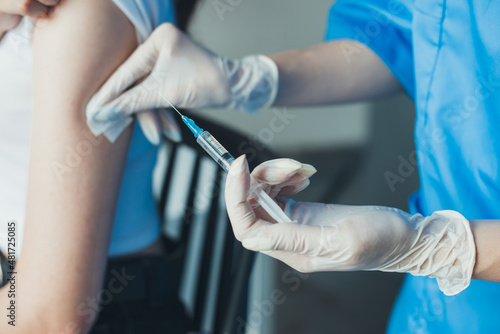 Closeup portrait of doctor's hands applying cotton pad on patient's arm. Virus protection. Doctor hand. Coronavirus vaccination.