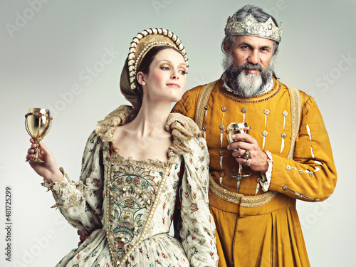 Living the lavish royal life. Studio shot of a king and queen drinking out of goblets.