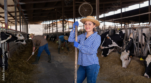 Portrait of positive young adult woman engaged in livestock breeding farm