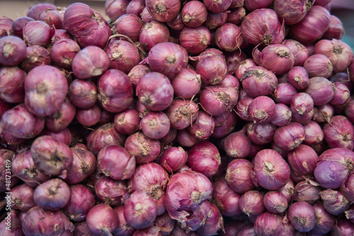 A pile of onions at a market in Hua Hin Thailand stacked and ready for sale. The onions are natural and fresh.
