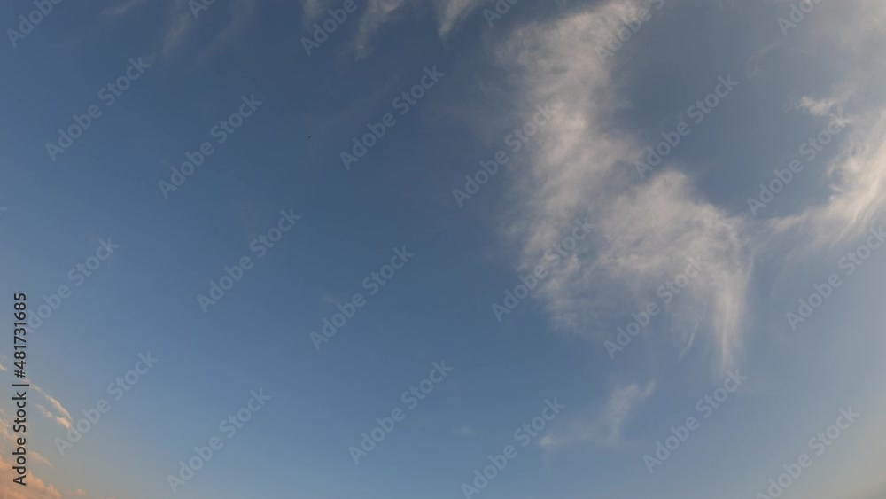 time lapse at sunset, with the clouds appearing, crossing and fading in the blue sky time lapse at sunset, with the clouds appearing, crossing and fading in the blue sky