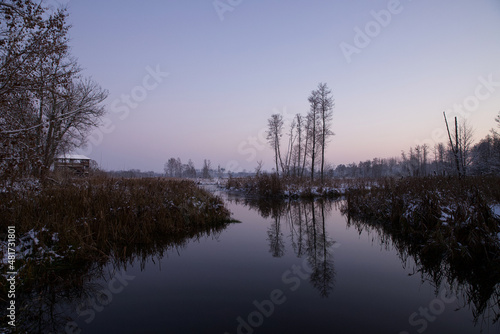 Landscape with a river, in winter scenery, at the evening time.