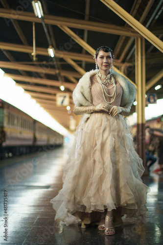 Retro vintage portrait of beautiful Gatsby woman stand look around, wait coming train for lover