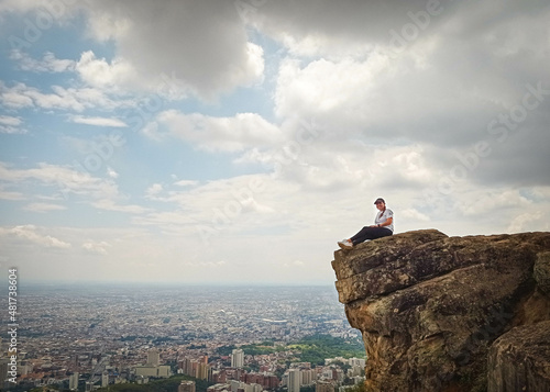 Obraz na plátně Mujer en la cima de una montaña sentado en una roca